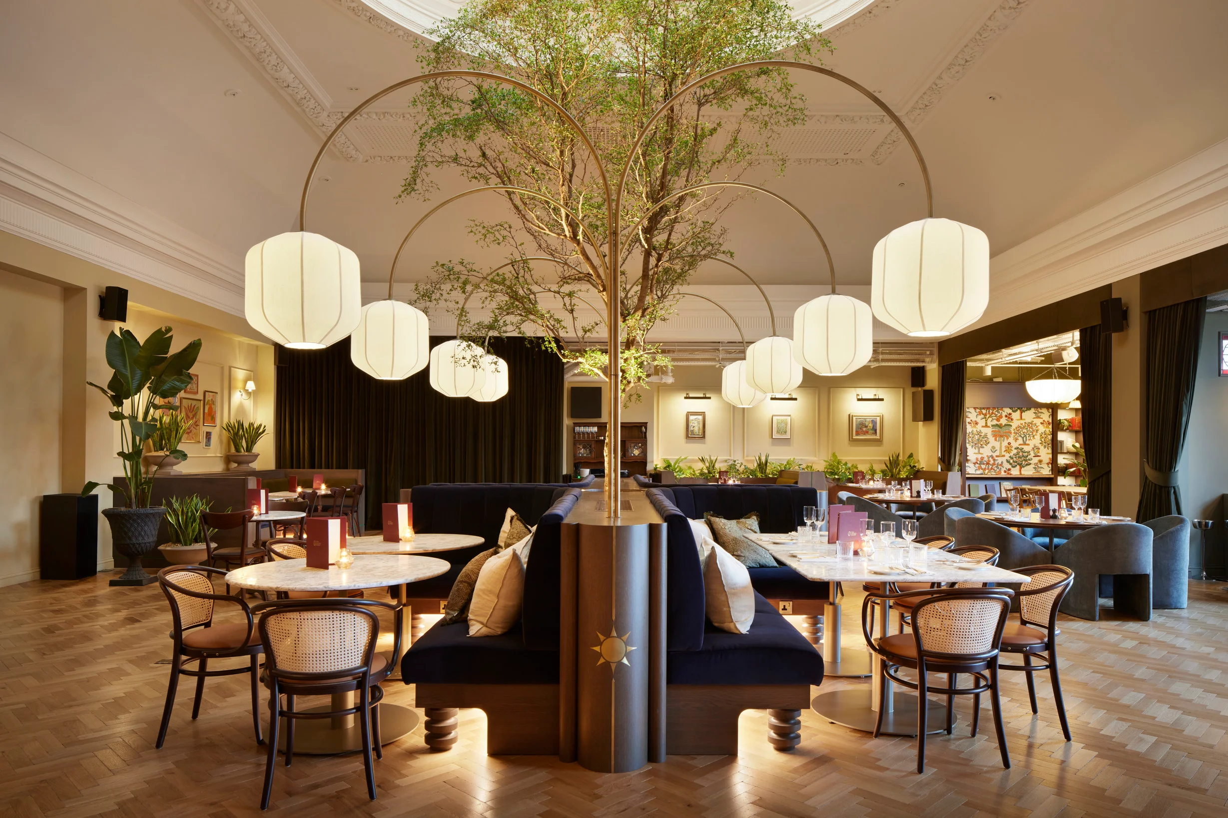 The restaurant at The Arding Room, paper lanterns hanging from a central tree over marble tables